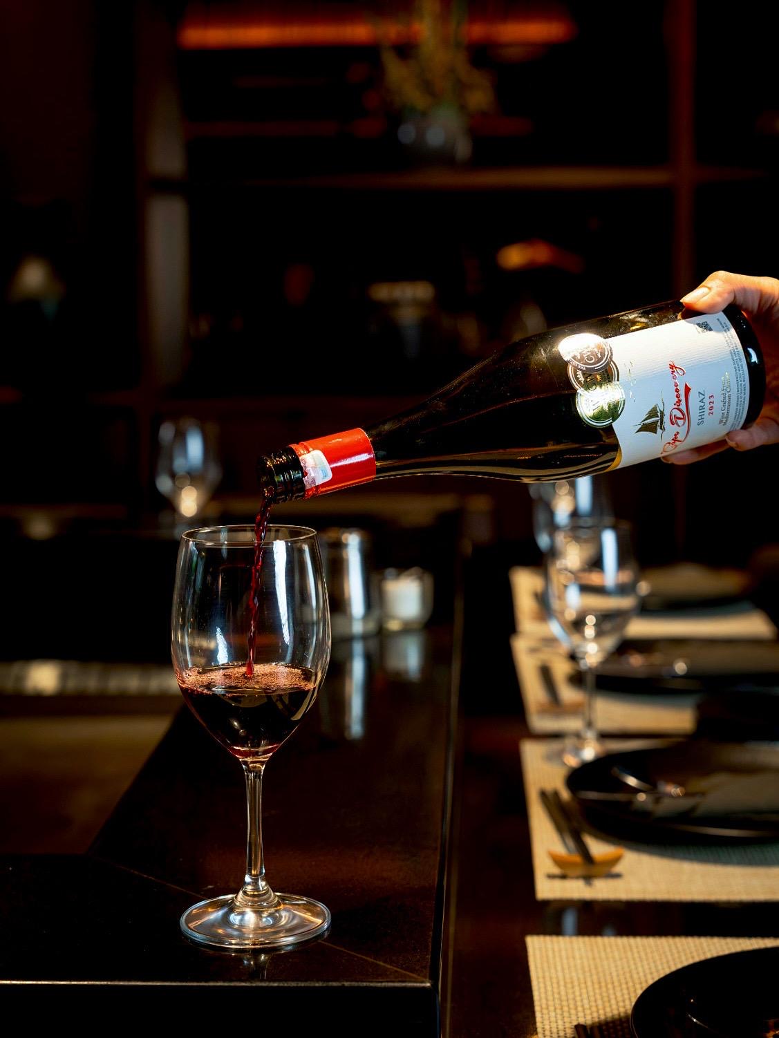 Red wine being poured at the bar